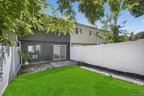 a backyard of a house with table and chairs