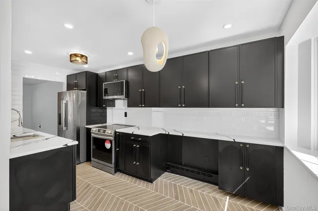 a kitchen with stainless steel appliances kitchen island granite countertop a refrigerator and a sink