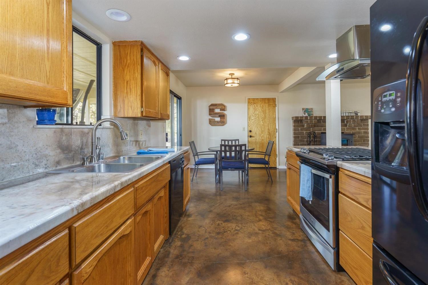 40410 Goldside Drive Oakhurst, CA 93644 - Photo 11 of 24 a kitchen with stainless steel appliances granite countertop sink stove and granite counter top