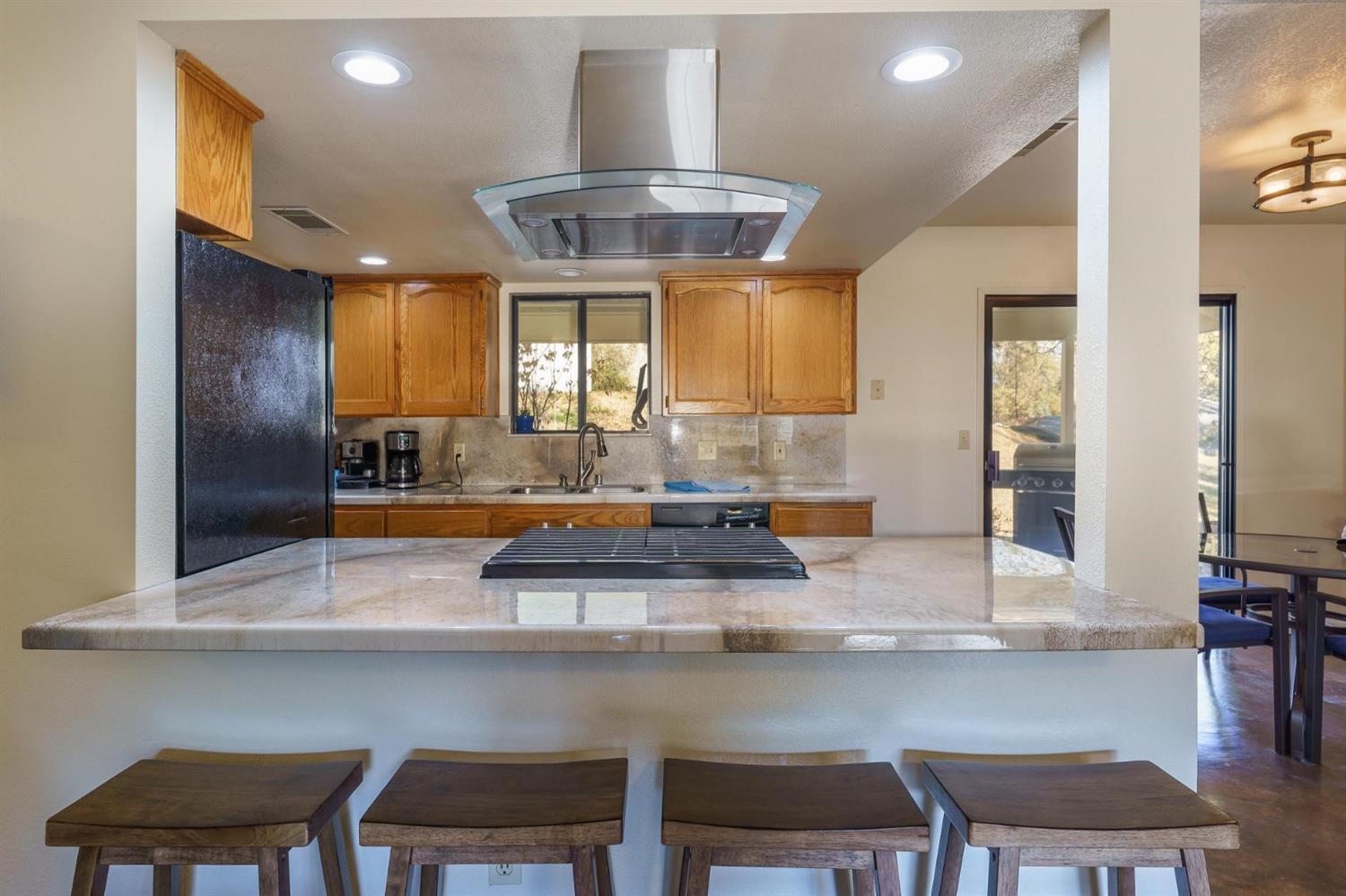 40410 Goldside Drive Oakhurst, CA 93644 - Photo 13 of 24 a kitchen with a table chairs refrigerator and cabinets