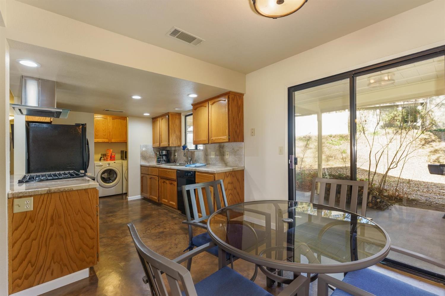 40410 Goldside Drive Oakhurst, CA 93644 - Photo 8 of 24 a kitchen with a table chairs refrigerator and microwave