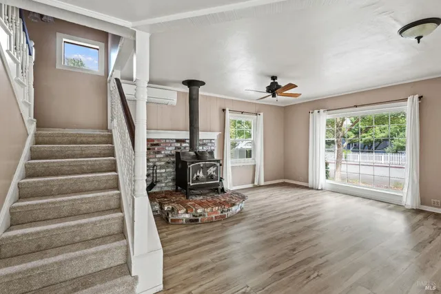 a view of a livingroom with wooden floor and a ceiling fan