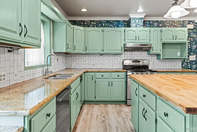a kitchen with a sink a stove and cabinets