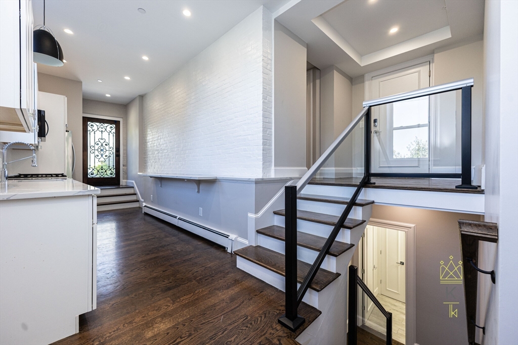 a view of entryway and hall with wooden floor