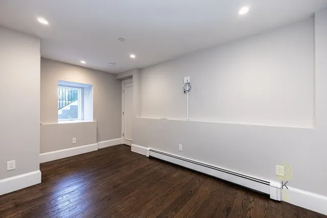 a view of an empty room with wooden floor