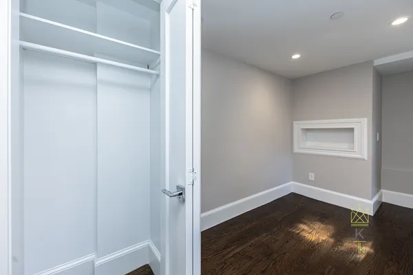 a view of empty room with wooden floor