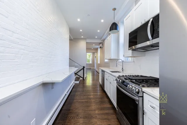 a kitchen with stainless steel appliances a stove a microwave and white cabinets