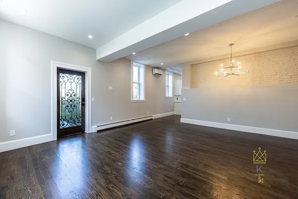 an empty room with wooden floor and window