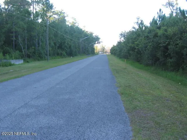 a view of a field with trees in background