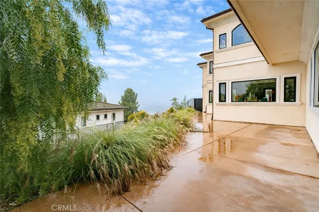 a view of a white house with many windows next to a yard
