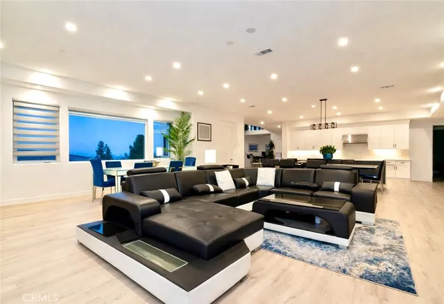 a living room with furniture kitchen view and a table