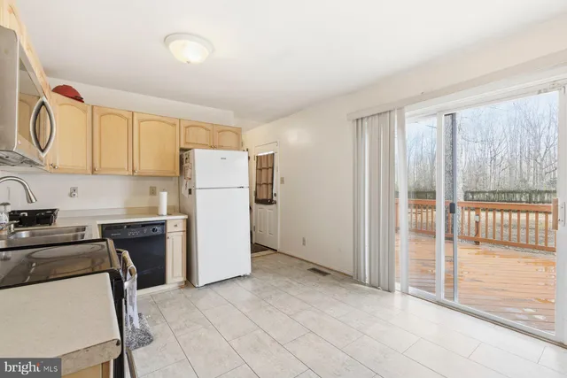 a kitchen with a refrigerator a stove top oven and a sink