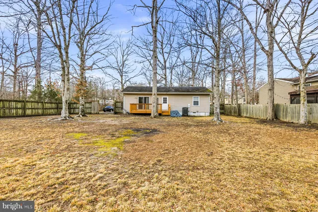 a front view of a house with a yard covered with snow and trees