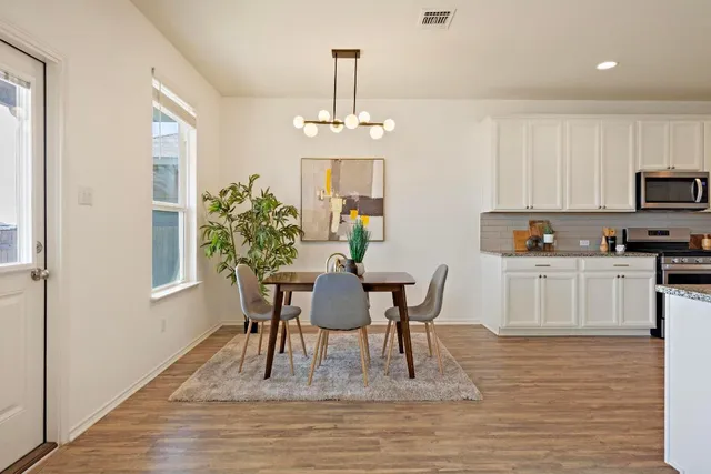 a dining room with furniture a chandelier and wooden floor