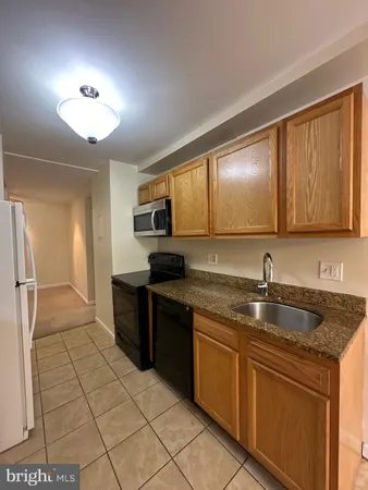 a large kitchen with granite countertop a sink and cabinets