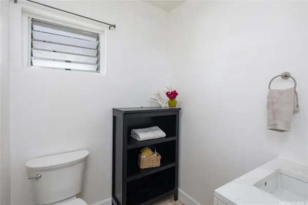 a bathroom with a toilet sink vanity and mirror