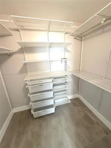 a view of walk in closet with empty racks
