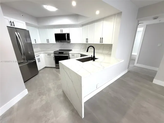 a kitchen with stainless steel appliances granite countertop a refrigerator sink and microwave