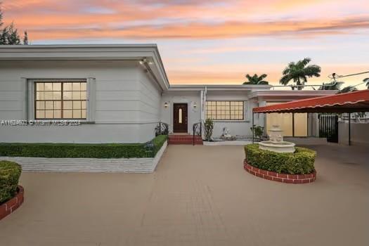 4144 Alton Road Miami Beach, FL 33140 - Photo 1 of 49 a front view of a house with a garden and mountain view