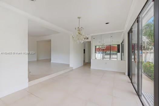 4144 Alton Road Miami Beach, FL 33140 - Photo 14 of 49 a view of a hallway with chandelier and glass door