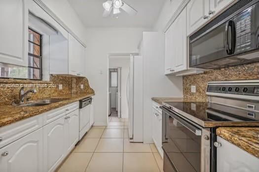 4144 Alton Road Miami Beach, FL 33140 - Photo 16 of 49 a kitchen with stainless steel appliances granite countertop a stove and a microwave