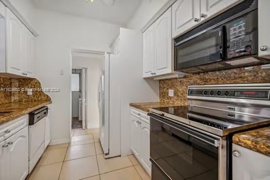 4144 Alton Road Miami Beach, FL 33140 - Photo 18 of 49 a kitchen with granite countertop a stove and a microwave