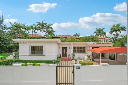 4144 Alton Road Miami Beach, FL 33140 - Photo 3 of 49 a front view of a house with a garden and plants