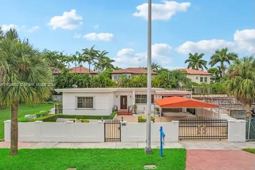 4144 Alton Road Miami Beach, FL 33140 - Photo 35 of 49 a front view of a house with a garden and plants