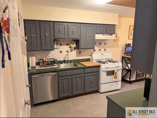 a kitchen with granite countertop a sink and white cabinets