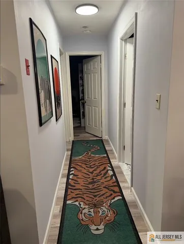 a view of a hallway with wooden floor and stairs
