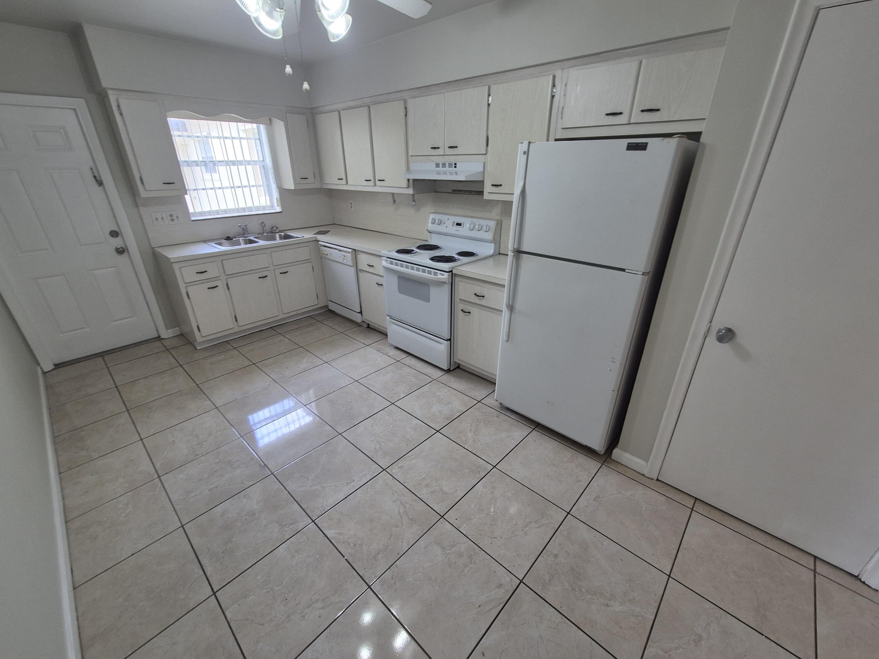 3709 Tyler Street Hollywood, FL 33021 - Photo 2 of 14 a kitchen with white cabinets and white appliances