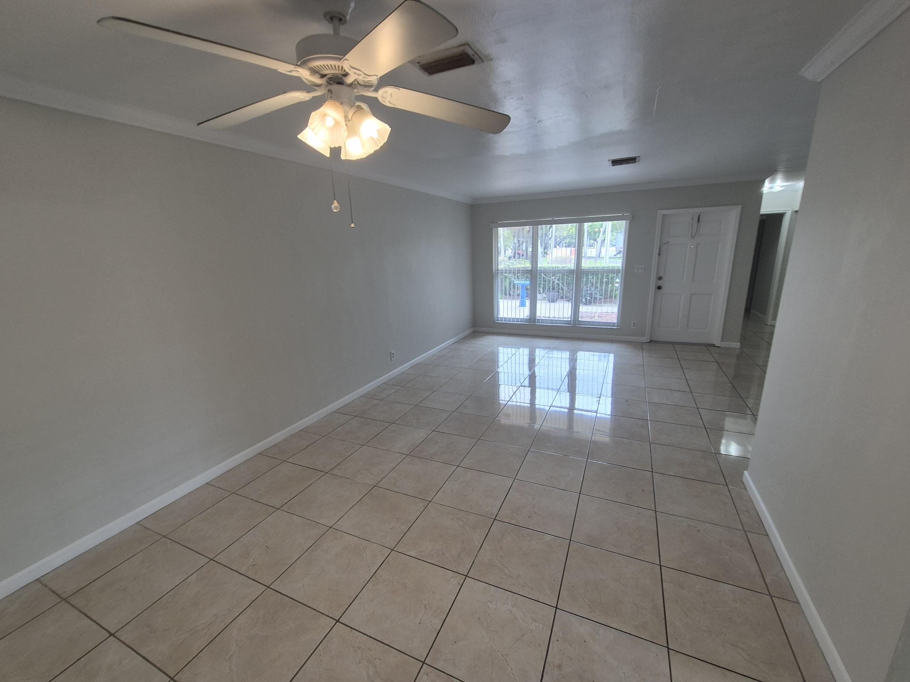 3709 Tyler Street Hollywood, FL 33021 - Photo 3 of 14 an empty room with chandelier fan and windows
