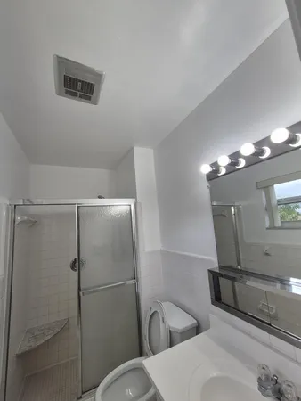 a bathroom with a toilet a sink and mirror