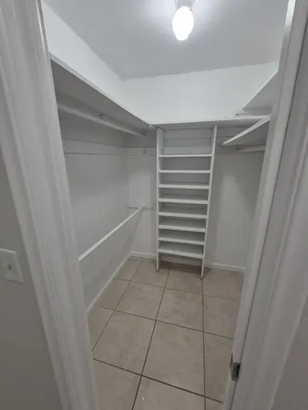a view of walk in closet with empty racks