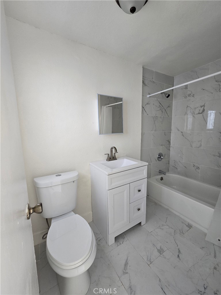 12226 East Valley Boulevard El Monte, CA 91732 - Photo 7 of 7 a bathroom with a granite countertop toilet a sink and a bathtub