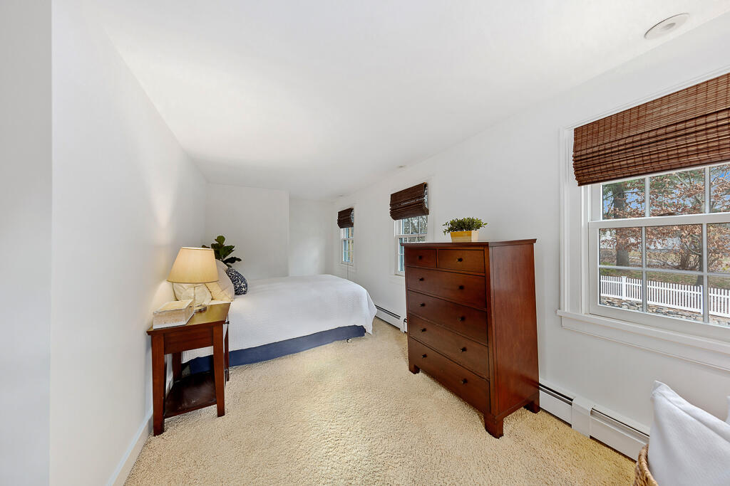 31 Brookside Road Darien, CT 06820 - Photo 21 of 34 a bedroom with a bed and wooden floor