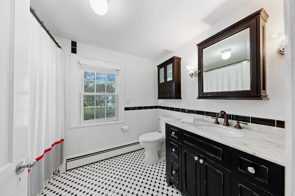31 Brookside Road Darien, CT 06820 - Photo 24 of 34 a bathroom with a sink a toilet a mirror a vanity and window