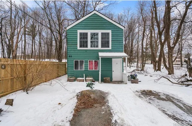 a view of a house with snow on the road