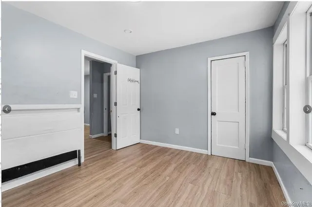 an empty room with wooden floor and closet