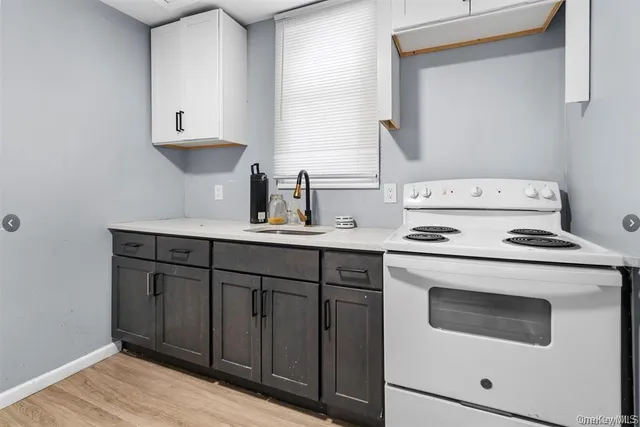 a kitchen with cabinets appliances a sink and a stove