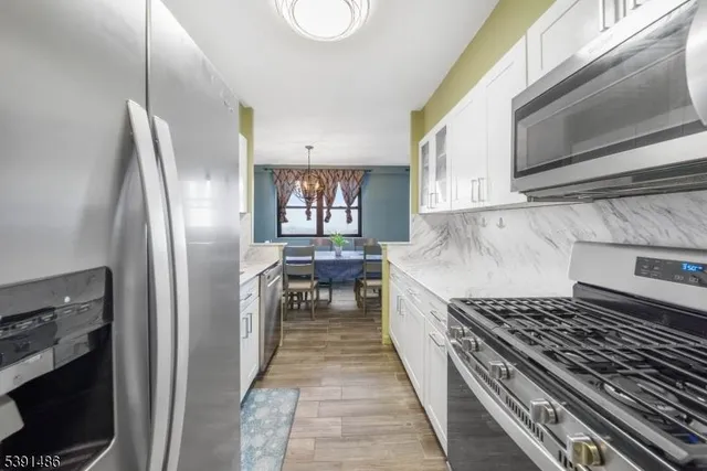 a kitchen with stainless steel appliances granite countertop a refrigerator and a stove top oven