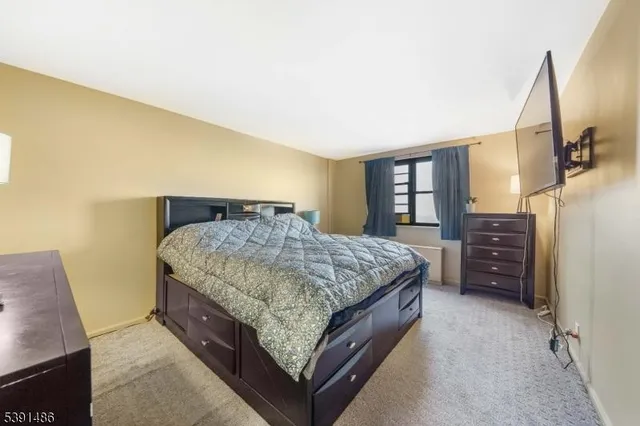 a bedroom with a bed a dresser and a large mirror