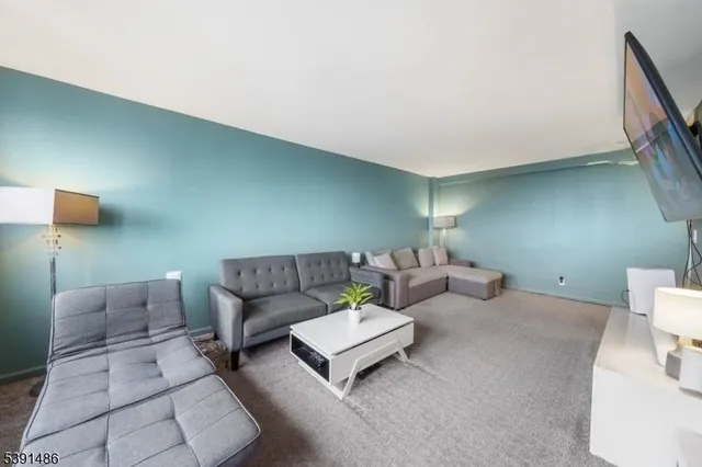 a living room with couches and a night stand