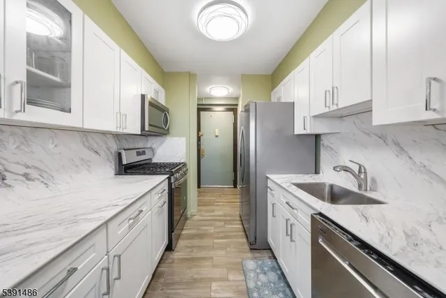 a kitchen with granite countertop a sink dishwasher stove and cabinets