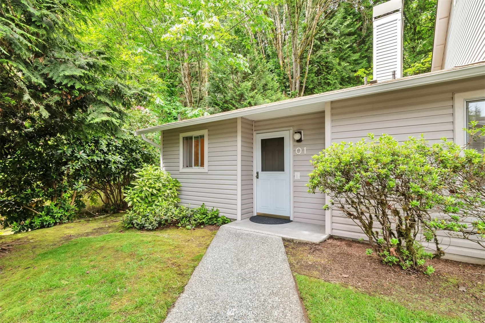 18910 Bothell Everett Highway, Unit O1 Bothell, WA 98012 - Photo 1 of 15 a front view of a house with garden