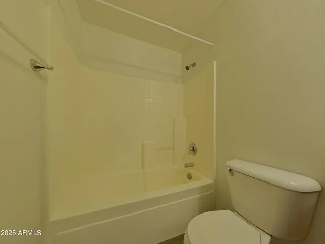 a white toilet sitting next to a bath tub and a shower