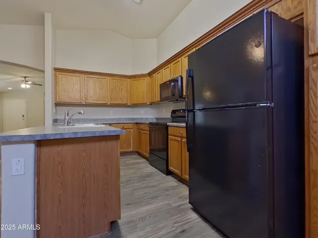 a kitchen with stainless steel appliances granite countertop a refrigerator and a stove top oven