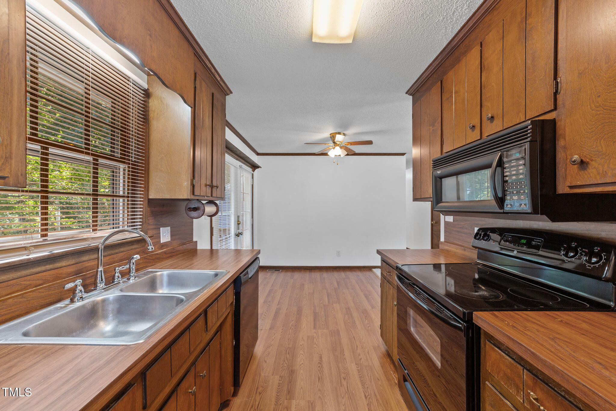 1101 Robinfield Drive Raleigh, NC 27603 - Photo 11 of 48 a kitchen that has a sink a stove and a wooden floor