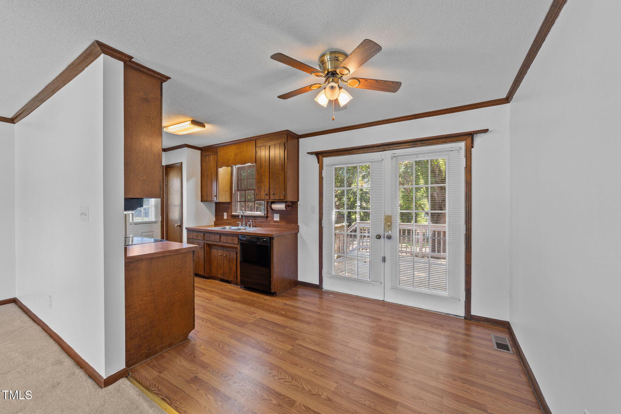 1101 Robinfield Drive Raleigh, NC 27603 - Photo 13 of 48 a view of a kitchen with a stove wooden floor a ceiling fan and windows