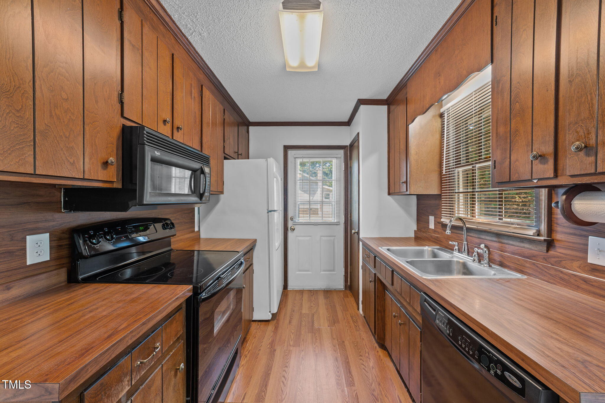 1101 Robinfield Drive Raleigh, NC 27603 - Photo 8 of 48 a kitchen with stainless steel appliances granite countertop a stove a sink dishwasher and wooden cabinets with wooden floor